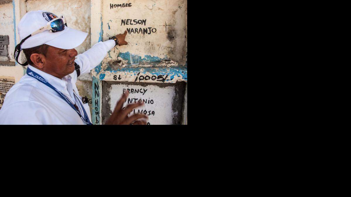
Cemetery Manager Henry Cárdenas in Puerto Berrio, Colombia, points to the crypt of an “NN” or “no name.” Such tombs are eagerly sought by locals who want to “adopt” the bodies.
