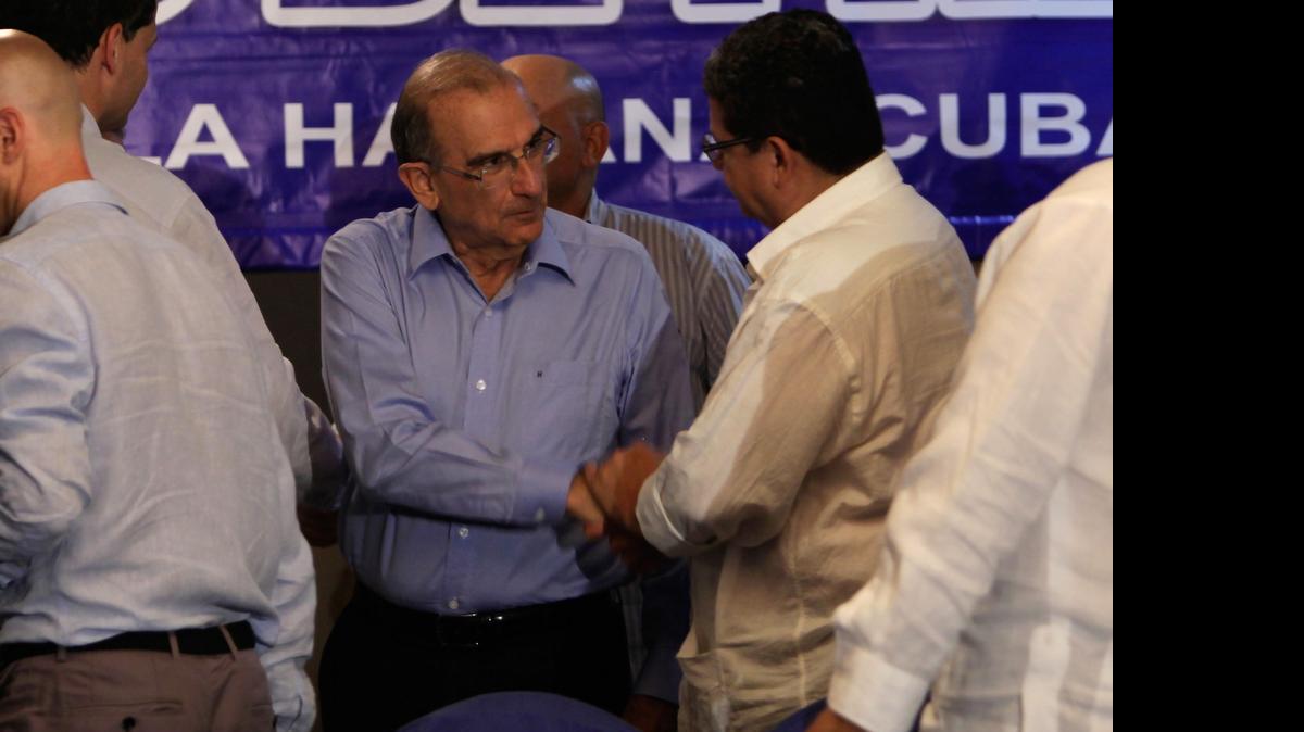 
Humberto de la Calle, center, head of Colombia's government peace negotiation team shakes hands with Pablo Catatumbo, chief of the FARC's western bloc after a joint statement in Havana, Cuba, Thursday, June. 4, 2015. 
