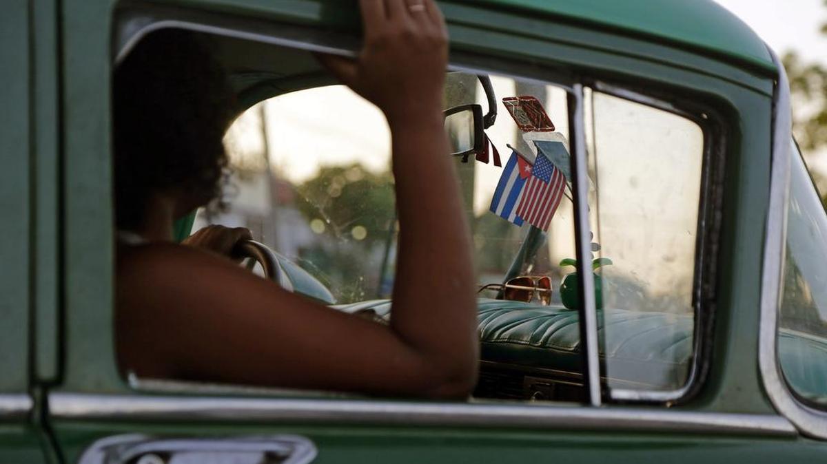 A woman sits in a private collective taxi decorated with the Cuban and U.S. flags in Havana, Cuba. File photo.