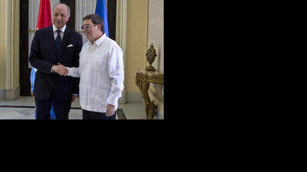 
Cuba's Foreign Minister Bruno Rodriguez, right, and France's Foreign Minister Laurent Fabius shake hands toward photographers prior to their meeting at the Foreign Ministry in Havana, Cuba, Saturday, April 12, 2014. France's foreign minister visited Cuba for the first time in 30 years at a time when the communist-led Caribbean nation is seeking to draw more foreign investment and improve ties with the European Union. 

