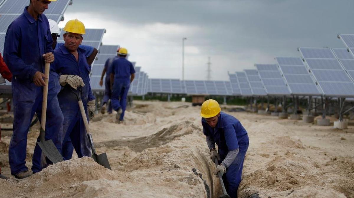 File photo: workers install a high-voltage power line that will carry the current generated by solar panels at Cuba's first solar farm in Cantarana. New regulatory changes would allow U.S. engineering and design firms to work on such infrastructure projects in Cuba.
