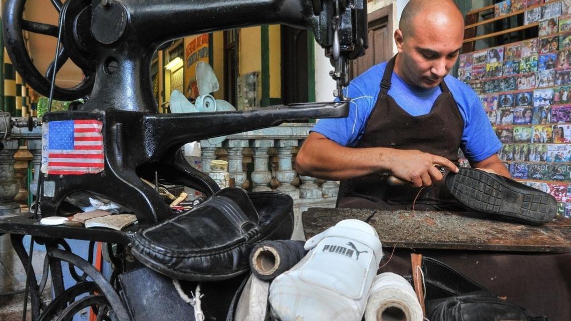 A private cobbler works near a U.S. flag in Havana, on January 16, 2015.
