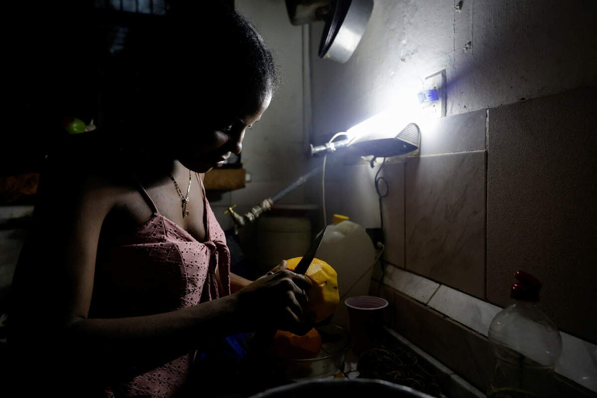 Maria Teresa Marti, 32, peels a mango for her children as Cuba's national power grid collapsed, marking the second total blackout in a week amid a severe energy crisis that has turned power outages into a daily reality, in Havana, Cuba, July 11, 2026.