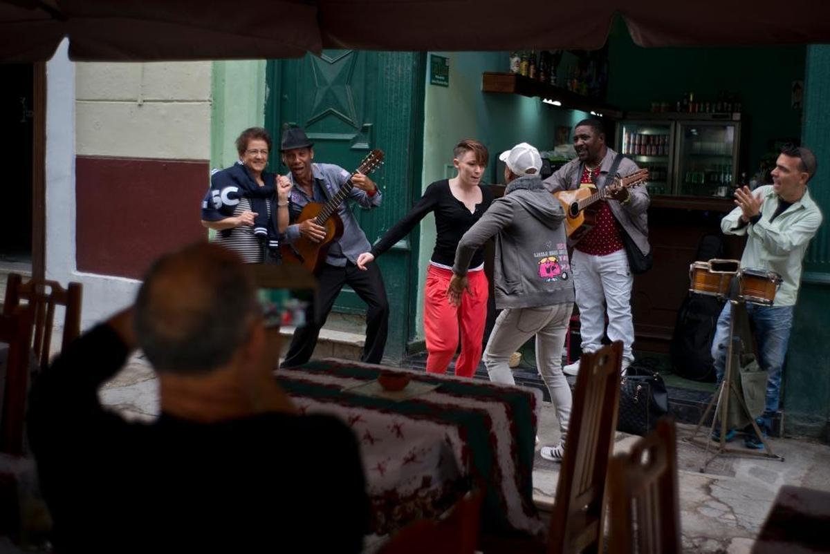 Visitors dance as musicians play at a bar in Havana. The number of American travelers rose to 619,000, more than six times the pre-Obama level. But amid the boom, an 18 percent increase over 2016, owners of private restaurants and bed-and-breakfasts are reporting a sharp drop-off.