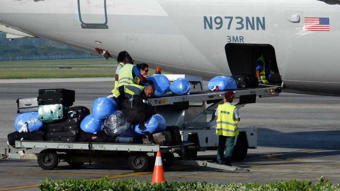 Workers load bags, some containing remittances, off of a recently arrived U.S. Airlines charter flight to Havana.