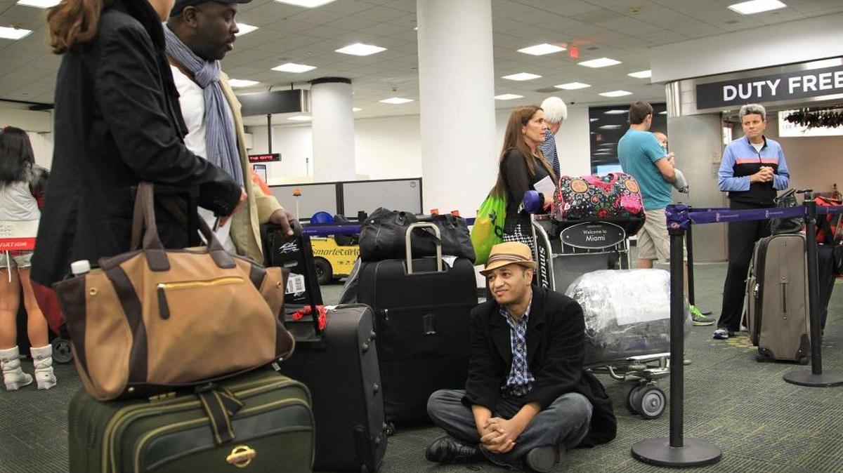 Robert Pryor, of Cleveland Ohio, waits to get his ticket at Miami International Airport for a charter offered by Island Travel & Tours. He was among the many people lining up for travel to Cuba on New Year's Day 2015.