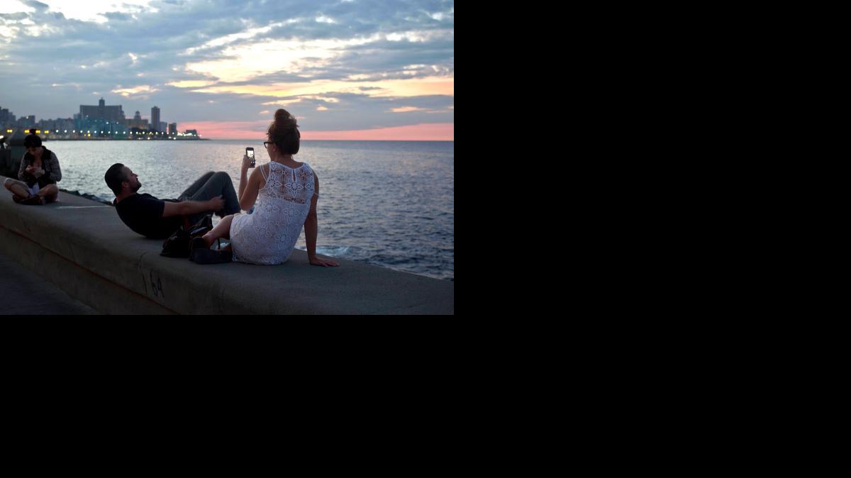 
Tourists enjoy taking photos at the Malecon in Havana, Cuba, Friday, Dec. 19, 2014. After a half-century of Cold War acrimony, the United States and Cuba abruptly moved on Wednesday to restore diplomatic relations, a historic shift that could revitalize the flow of money and people across the narrow waters that separate the two nations. 
