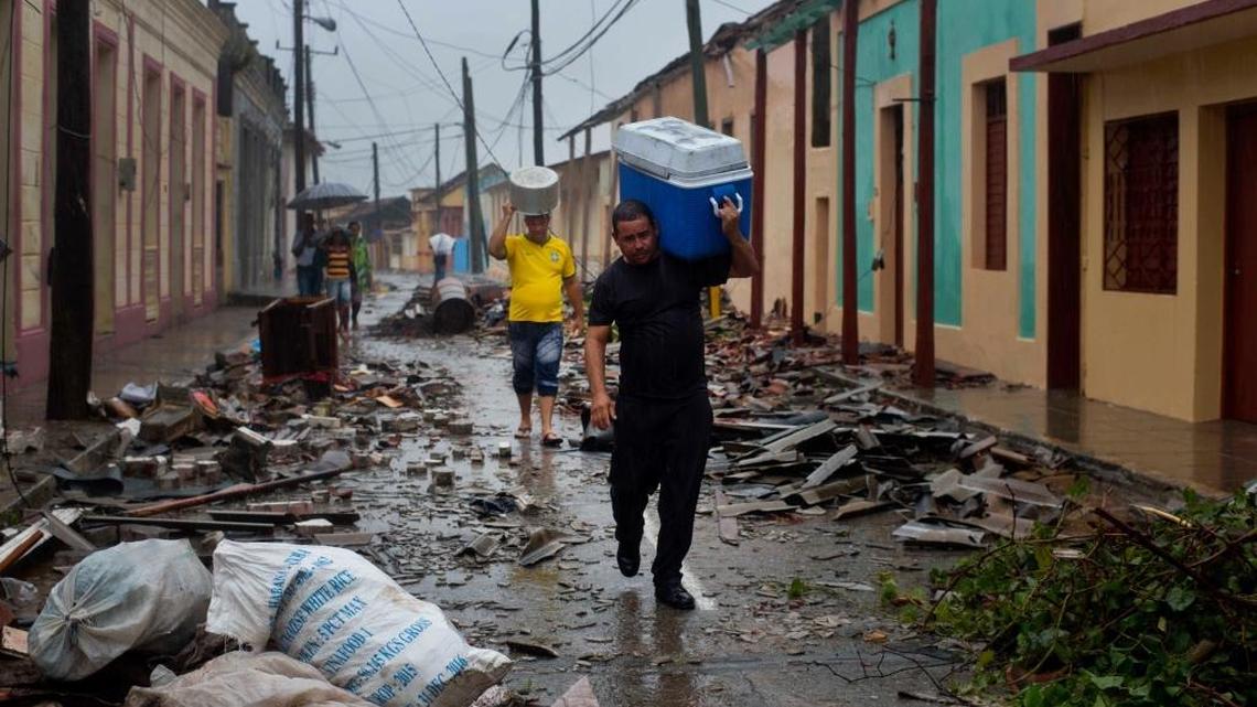 In October 2016, Hurricane Matthew walloped Baracoa, Cuba. Now Cuban authorities have begun to prepare for the approach of Hurricane Irma. In this file photo from last year, residents carry food down a street strewn with rubble in Cuba’s easternmost city.