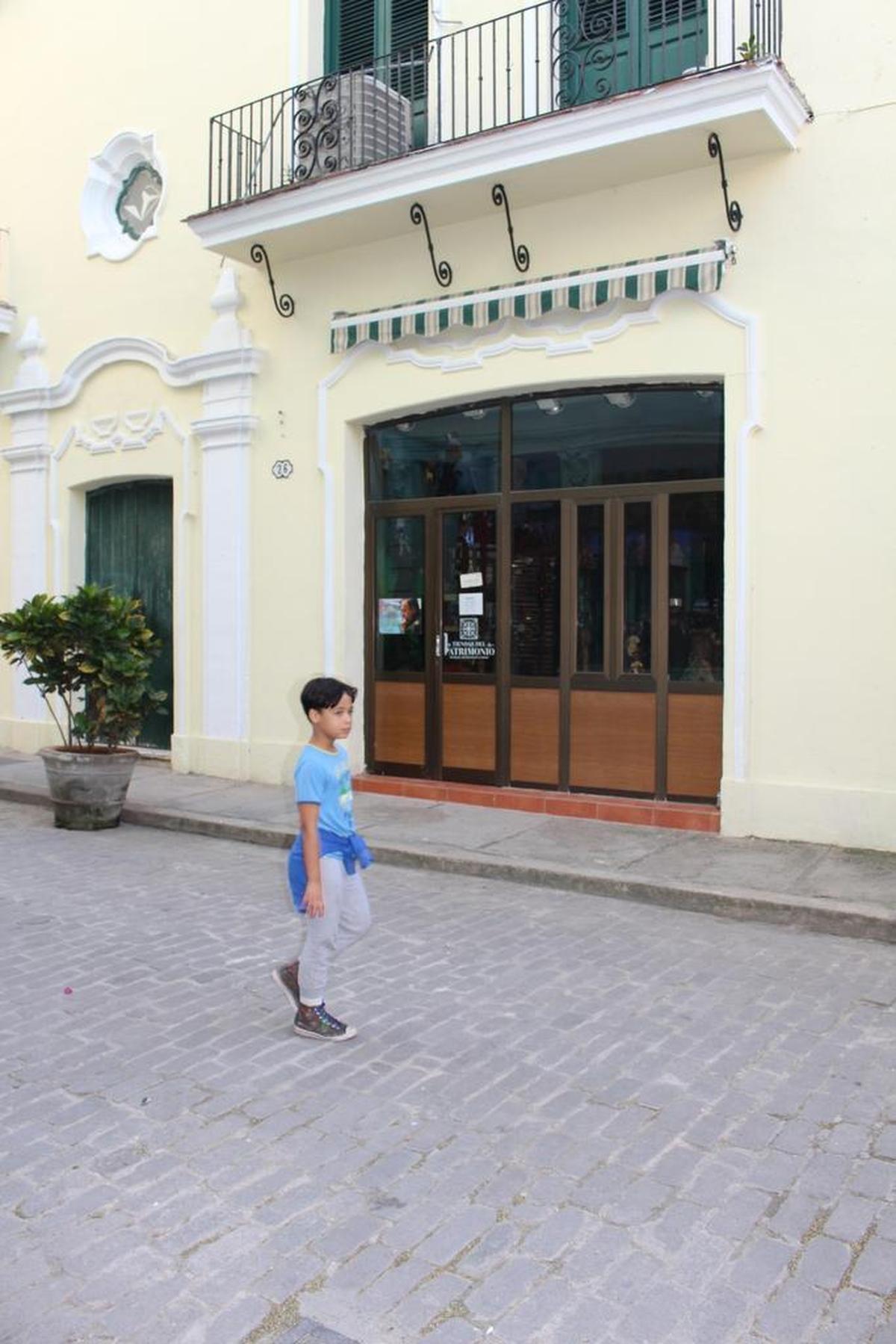 A boy passes Muñecos de Leyenda, a doll store in Old Havana that is on the restricted list.