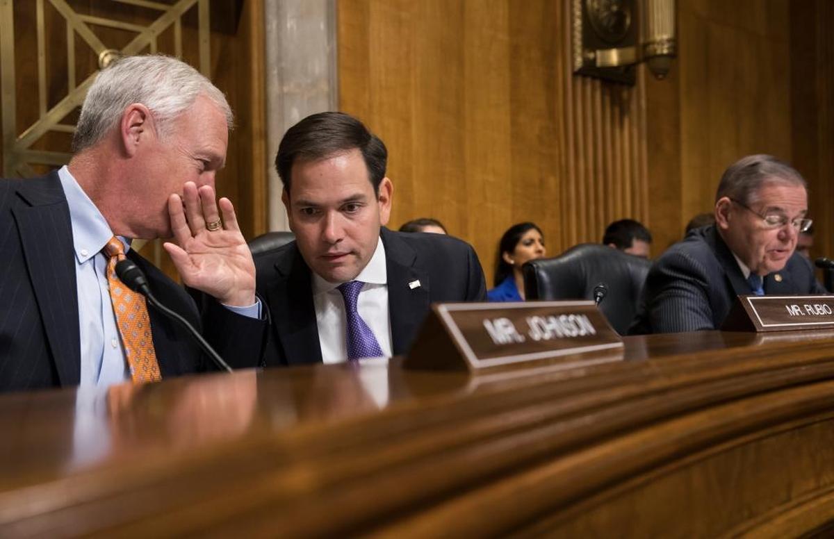 Sen. Marco Rubio, R-Fla., center, confers with Sen. Ron Johnson, R-Wisc., left, while Sen. Bob Menendez, D-N.J., far right, speaks as a Senate Foreign Relations subcommittee examines attacks on American diplomats in Havana.