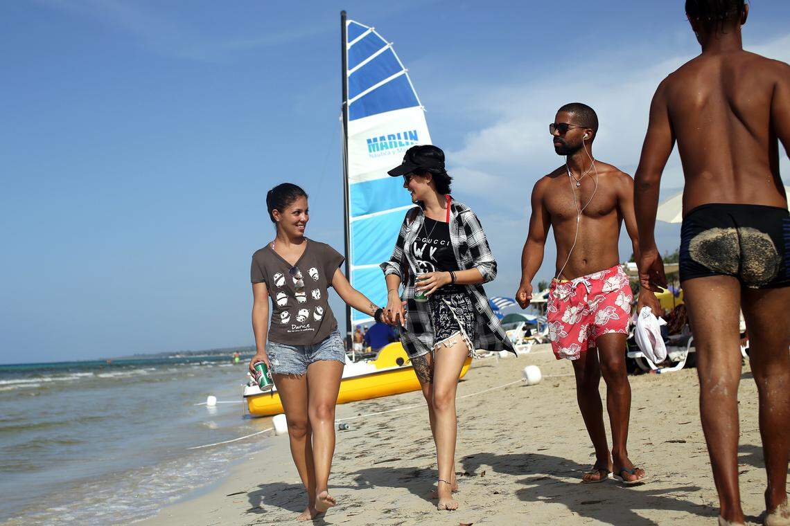 Yuli Delgado, 27, far left, and Betsy Conde, 23, a Cuban couple, walk along the beach of Mi Cayito in Havana, a meeting place for the gay community.