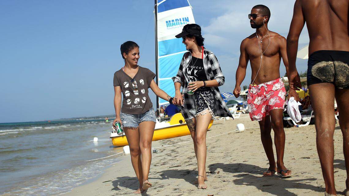 Yuli Delgado, 27, left, and Betsy Conde, 23, a Cuban couple, walk along the beach of Mi Cayito in Havana, a meeting place for the gay community.