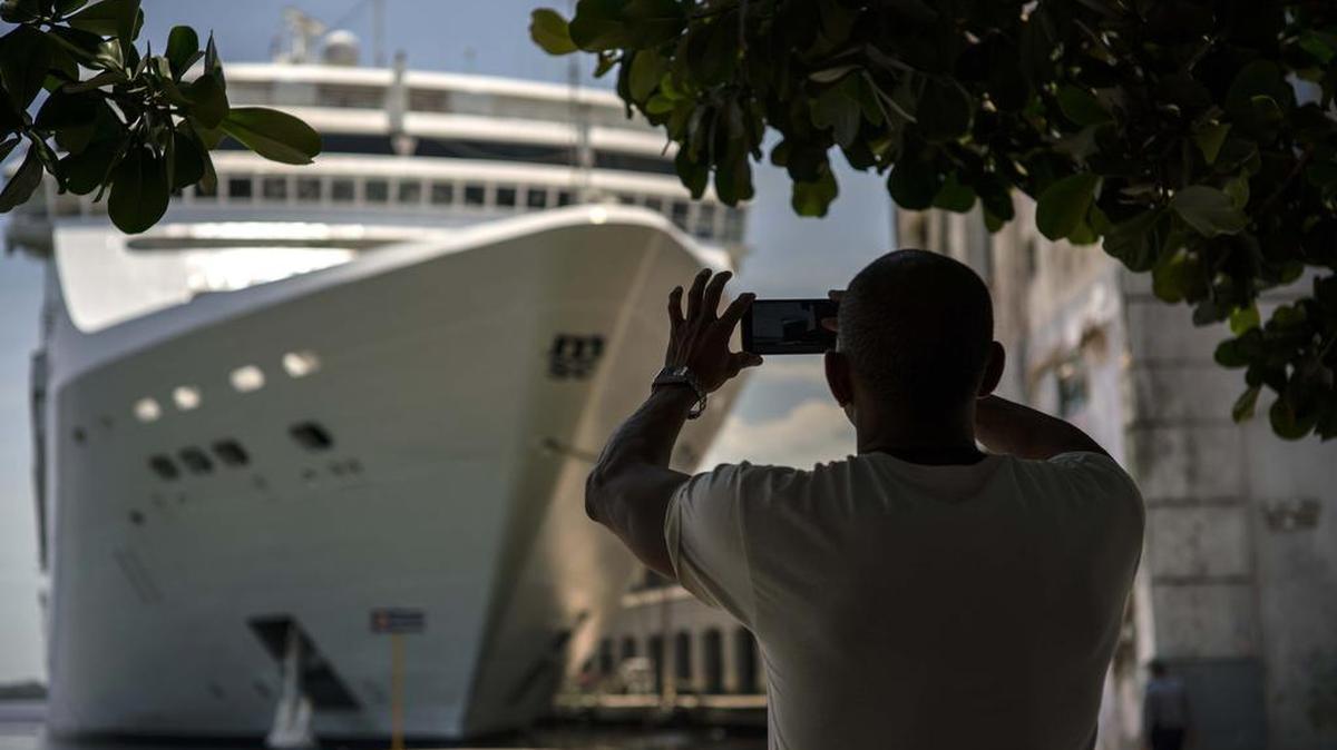 A man takes a photo of a cruise ship in Havana harbor. President Donald Trump’s new Cuba policy will ban Americans from doing business with entities controlled by Cuban military and intelligence agencies, including some 50 hotels. It also will eliminate individual people-to-people visits as an approved category for American travel to the island.