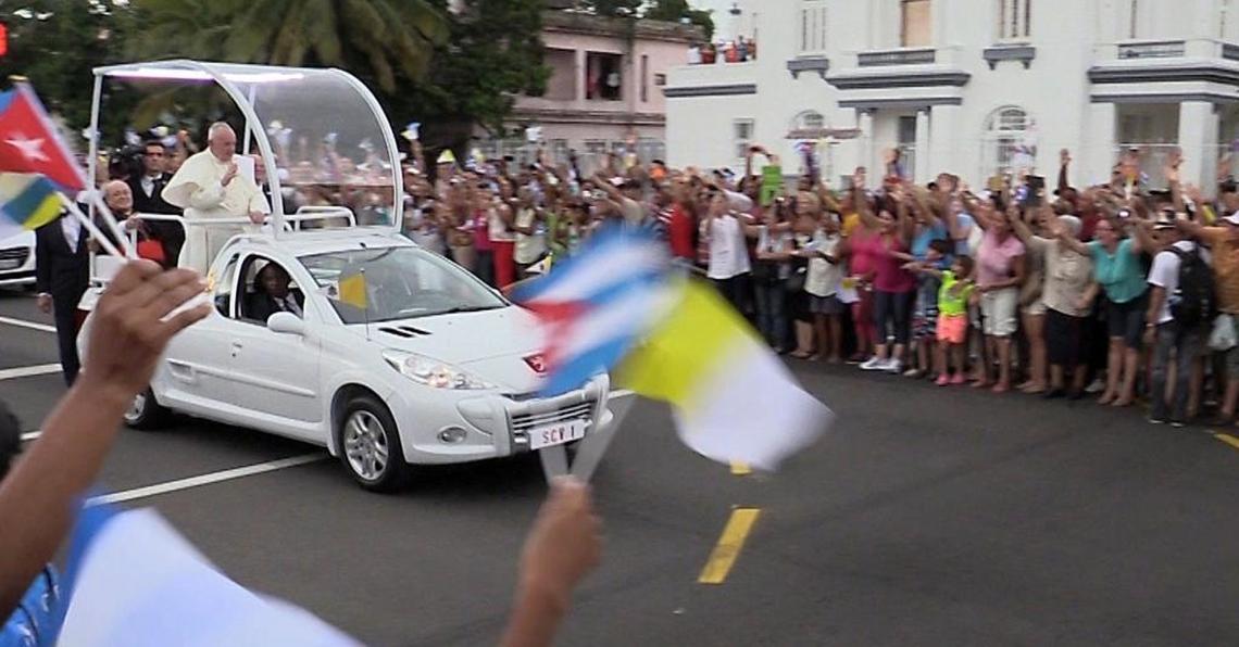 Pope Francis waves to crowds lining the streets of Havana Saturday afternoon as his Pope mobile passes by. The Pope arrived in Havana Saturday afternoon, Sept. 19, 2015 .