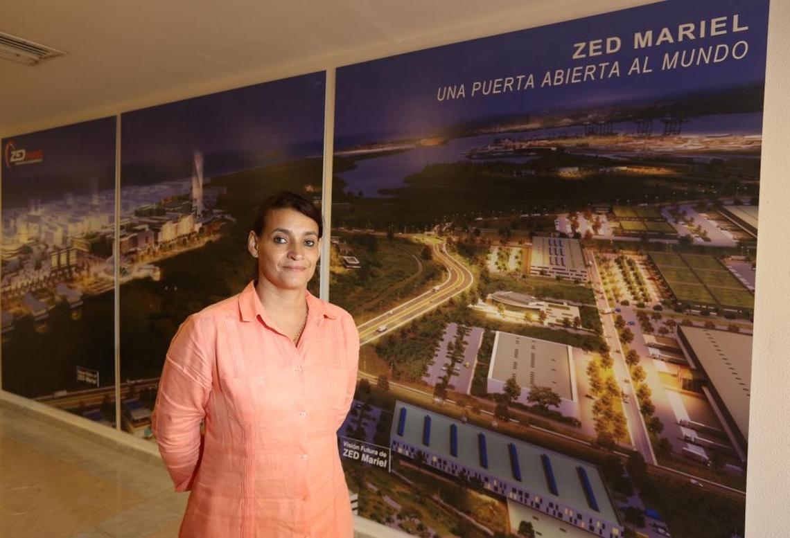 Ana Teresa Igarza, director of the Mariel Special Economic Development Zone, stands near a large mural that shows what the zone is expected to look like once construction is completed. Currently Cuba has approved the plans of 27 enterprises.