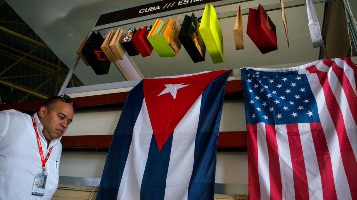 A man walks past Cuban and U.S. flags at the 33rd Havana International Fair in Havana on Nov. 2, 2015. The fair had something new: the electric buzz of business hustling to capitalize on what many feel will be a boom set off by the start of the normalization of relations with the U.S.