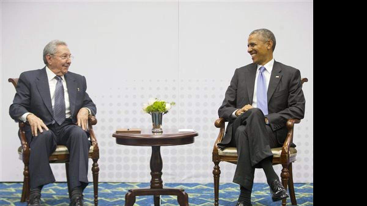 In this Saturday, April 11, 2015 photo, U.S. President Barack Obama, right, smiles as he looks over towards Cuban President Raul Castro, left, during their historic meeting, at the Summit of the Americas in Panama City, Panama. The leaders of the United States and Cuba held their first formal meeting in more than half a century on Saturday, clearing the way for a normalization of relations that had seemed unthinkable to both Cubans and Americans for generations.
