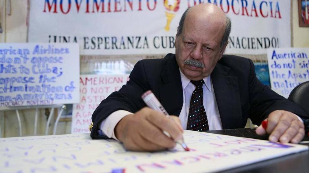 Felipe Rojas of the Democracy Movement makes signs for protests against American Airlines.