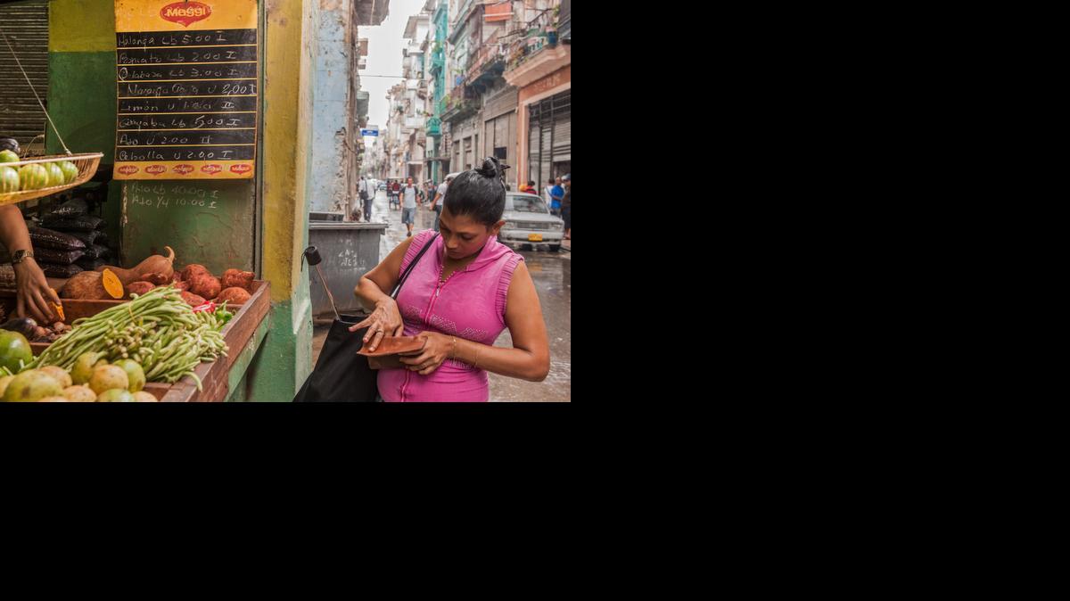 
A woman purchases vegetables at a stand in Old Havana.

