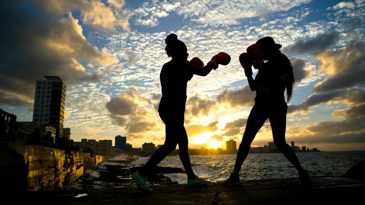 In this Jan. 30, 2017 photo, boxers Idamerys Moreno, left, and Legnis Cala, train during a photo session on Havana's sea wall, in Cuba. Moreno and Cala are part of a group of up-and-coming female boxers on the island who want government support to form Cuba's first female boxing team and help dispel a decades-old belief once summed up by a former top coach: "Cuban women are meant to show the beauty of their face, not receive punches."