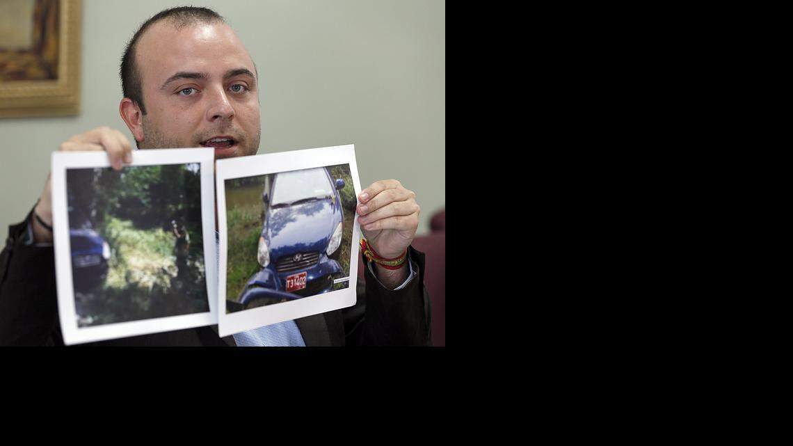 
Angel Carromero holds up photographs of the car in which Cuban dissident Oswaldo Paya was killed in a crash.
