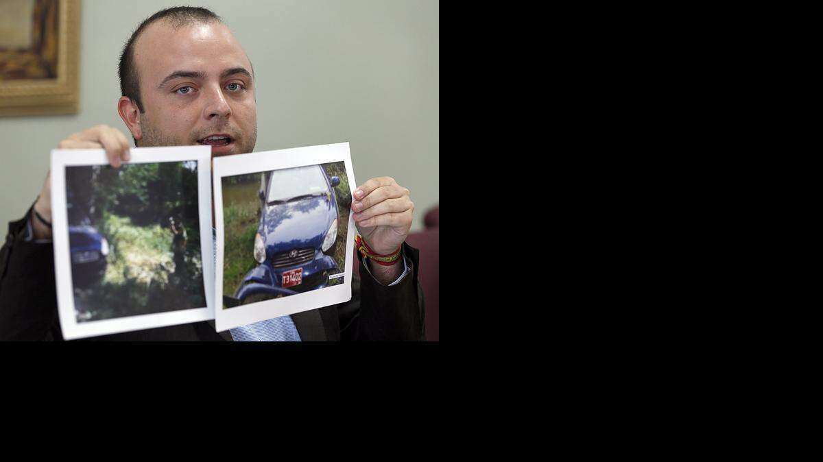 
Angel Carromero holds up photographs of the car in which Cuban dissident Oswaldo Paya was killed in a crash.
