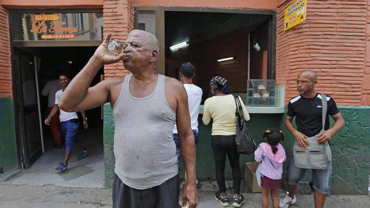Roberto Geilbert drinks soda water and a piece of bread purchased from Los Fornos Bar-Cafeteria in Havana, Cuba.