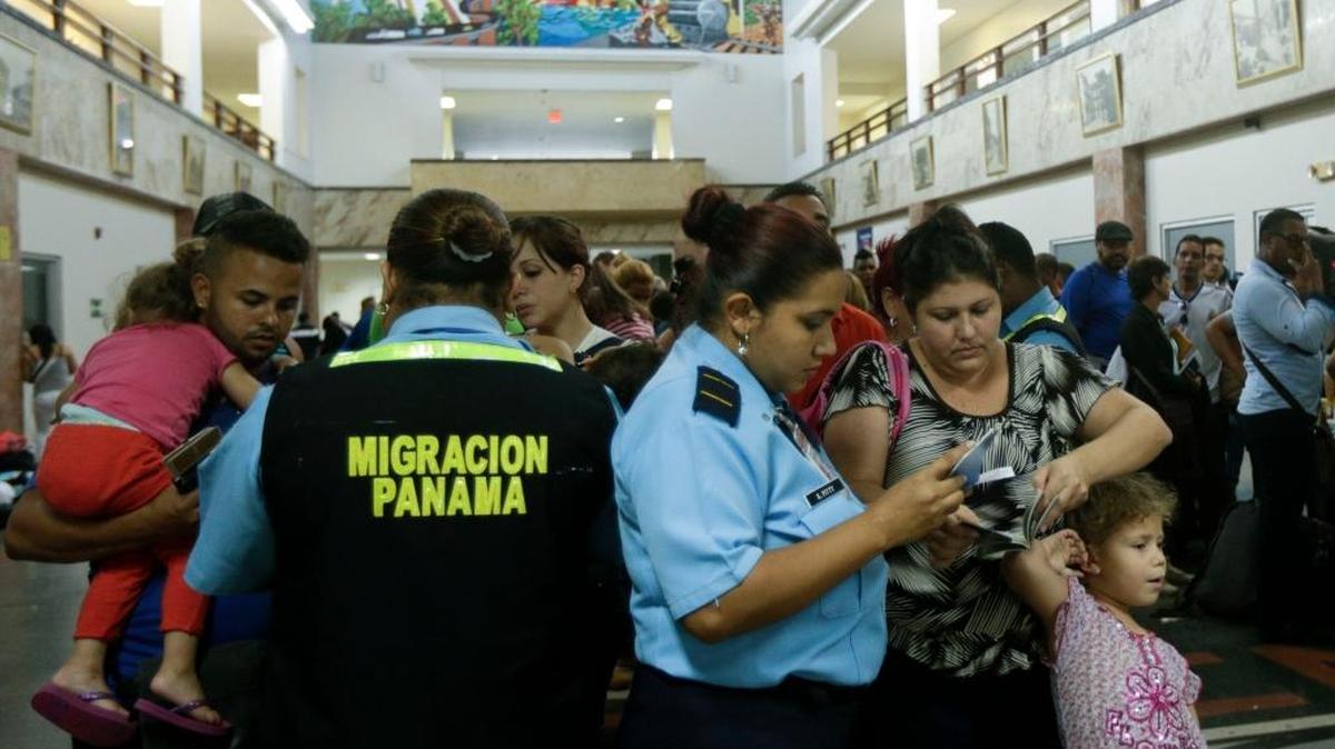 Migration officers review the documents of Cuban migrants before they board a chartered flight, in Panama City.