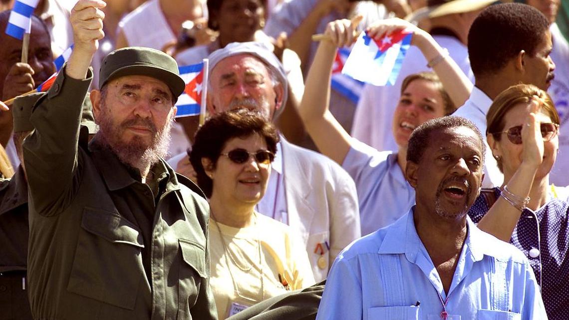 In this file photo, former Cuban leader Fidel Castro waves a Cuban flag while the Rev. Lucius Walker, right, sings during a protest in front of the former U.S Interests Section's building in Havana, Cuba.