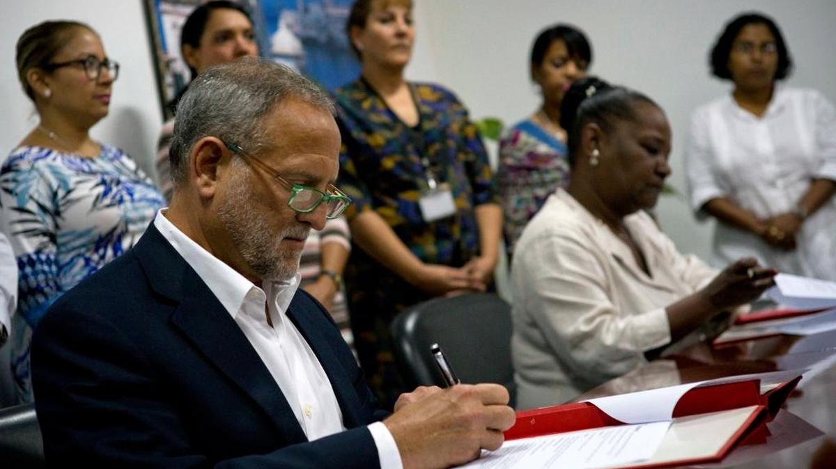 Attorney Scott Gilbert, left, president of the US company Coabana Trading LLC and Isabel O'Reilly, director of CubaExport, sign an agreement allowing the export of Cuban charcoal to the United States in Havana, Cuba.