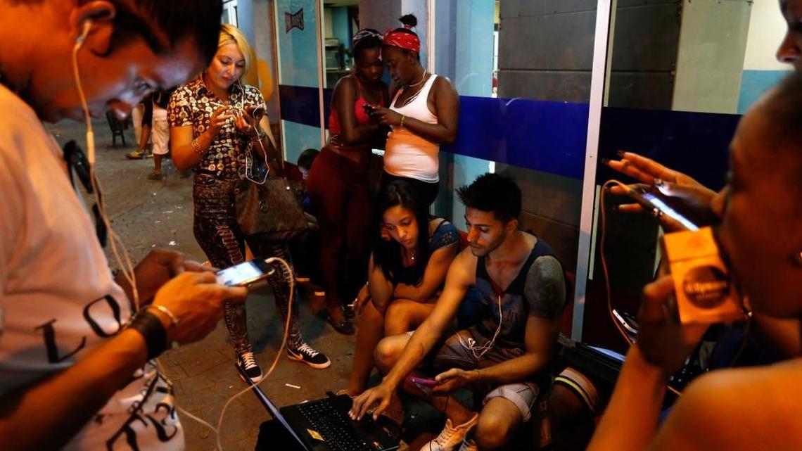 People surf the internet at a public WiFi hotspot in downtown Havana, Cuba.
