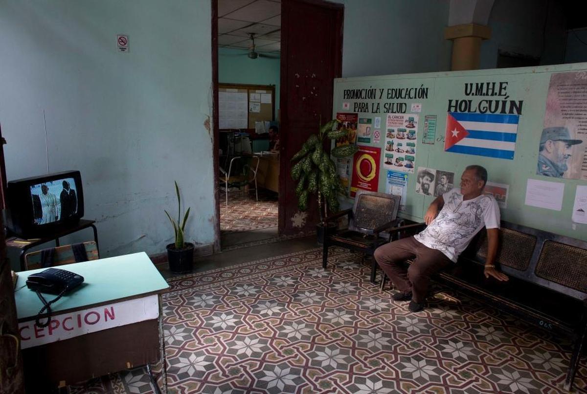 A man watches the arrival airport ceremony for Pope Francis in the capital on a television set at a government office in Holguin, Cuba, Saturday, Sept. 19, 2015. 