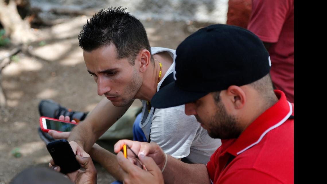 
Internet users go online with their smartphones using the first public Wi-Fi hotspot in Havana, Cuba on Thursday, July 2, 2015.
