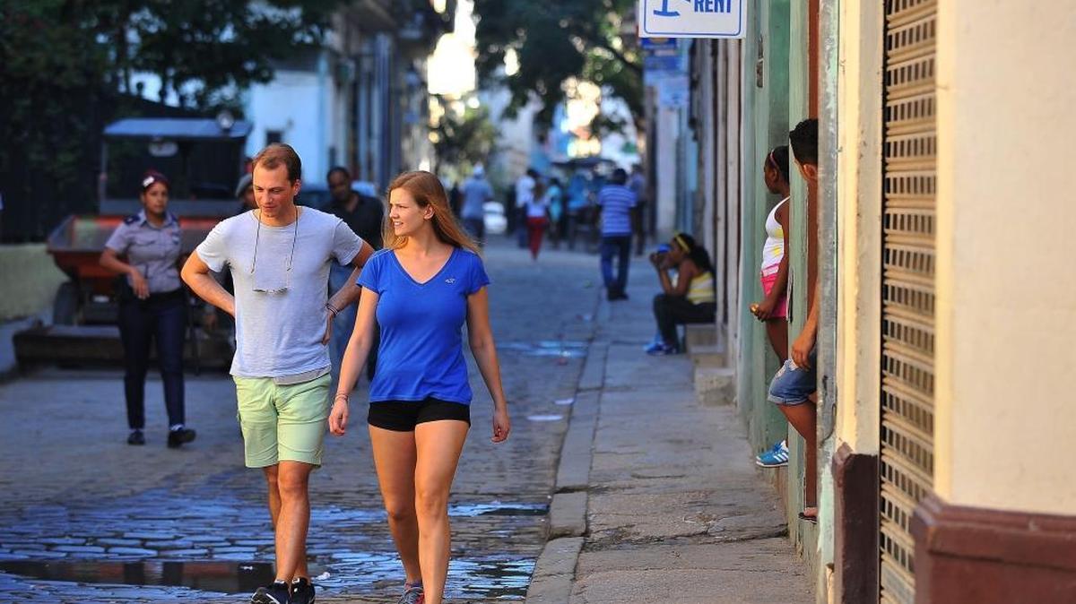 Tourists walk next to a house with a private room for rent in Havana, on February 10, 2017. Under new travel rules, U.S. visitors won’t be able to stay at hotels operated by the Cuban military.