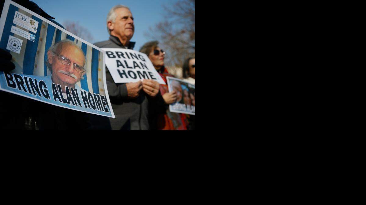 
In this Dec. 3, 2013 file photo, supporters of Alan Gross, on poster at left, mark his fourth year in a Cuban prison with a protest in Lafayette Park, across from the White House in Washington, D.C. 
