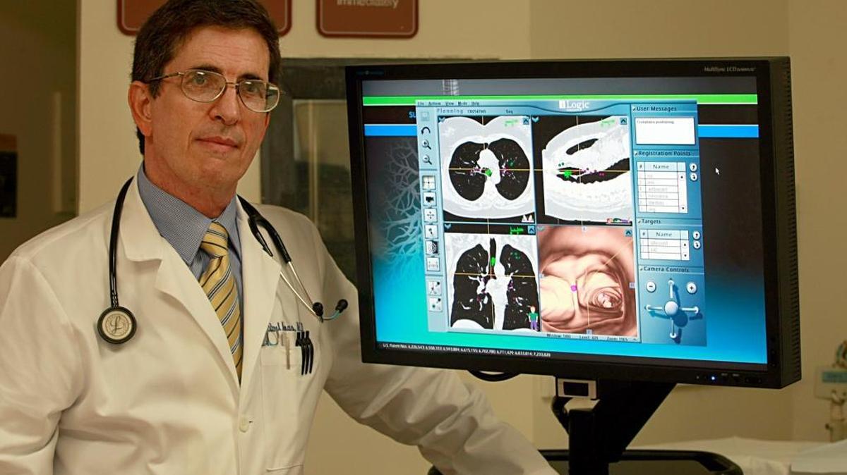 Filo photo: Dr. Raul Moas a pulmonary physician, stands next to an Electromagnetic Navigation Bronchoscopy equipment, used to detect lung cancer.