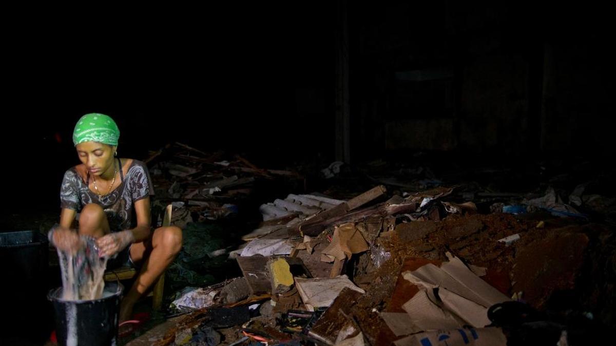 Dental student Julia Elena Azahares, 23, washes clothes amid wreckage caused by Hurricane Matthew, in Baracoa, Cuba.