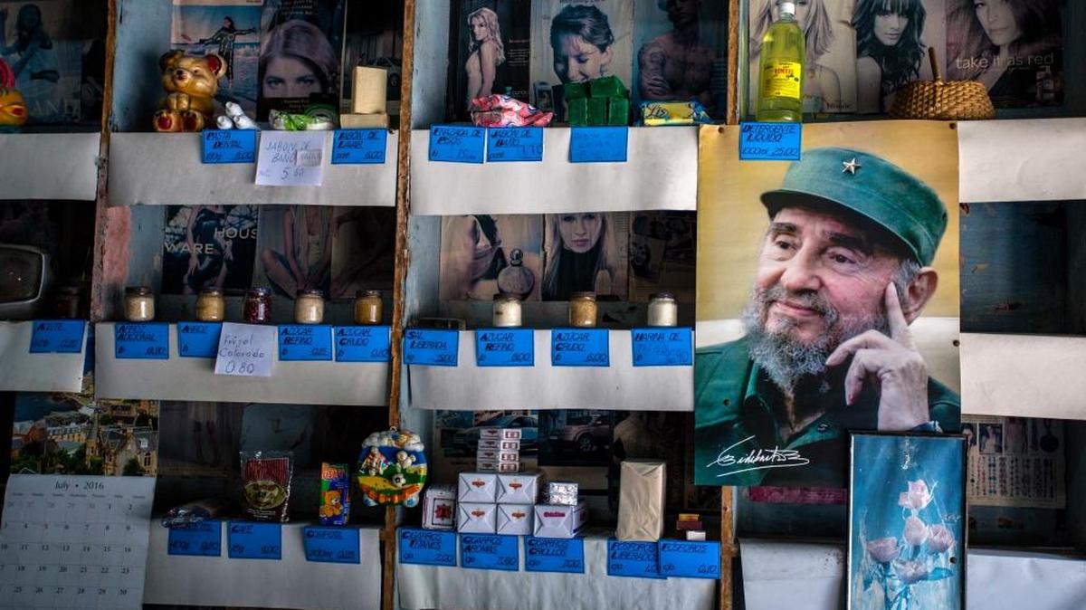 In this file photo, a picture of Cuban Revolution leader Fidel Castro is placed on the shelves of a state rationing store or "bodega," ahead of his upcoming 90th birthday in Havana, Cuba.