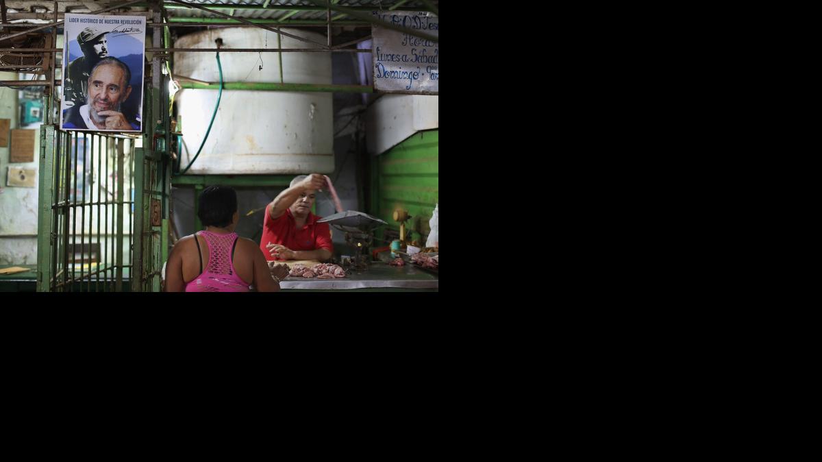 
HAVANA, CUBA - JANUARY 24: Under a poster of former Cuban President Fidel Castro, a woman buys pork in an open air market in the Jesus Maria neighborhood of Habana Vieja January 24, 2015 in Havana, Cuba. After the Cuban government expanded the list of accepted private small businesses between 2010 and 2012, about 1 million people, 20 percent of the Cuban workforce, can now be classified as wholly in the private sector. Diplomats from the United States and Cuba held historic talks this week that could restore diplomatic ties and mark the end of more than 50 years of of Cold War-era hostility between the two countries. 

