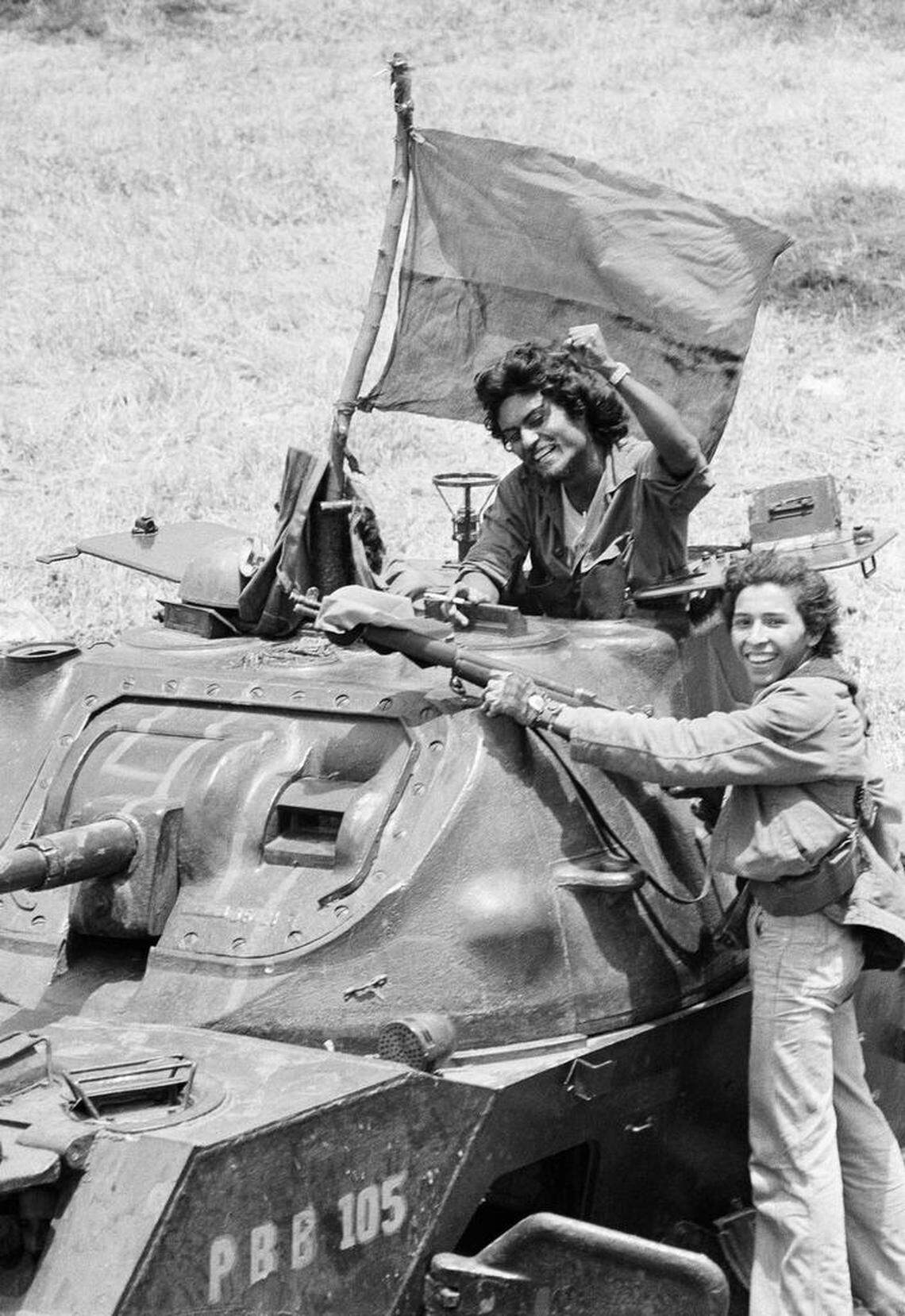 A pair of jubilant Sandinista guerrillas ride into Managua on a tank flying a guerrilla flag on June 19, 1979 in Managua, Nicaragua.