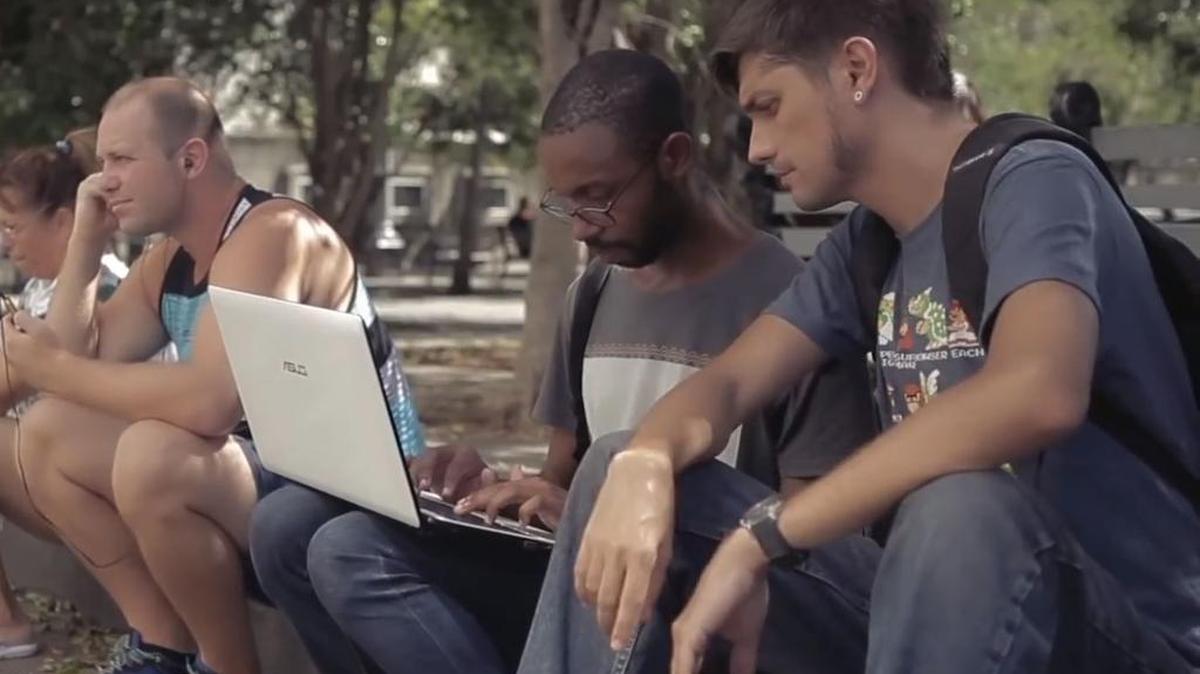Josuhe Pagliery (right) and Johann Armenteros (second from right), of Empty Head Games, connect to internet at a WiFi hotspot in Havana.