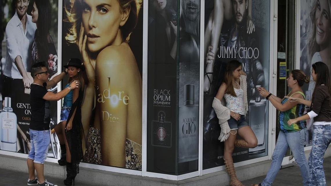Girls model for quinceañera photos at an International Trade Market that features U.S.-style advertising in Mariel, Cuba.