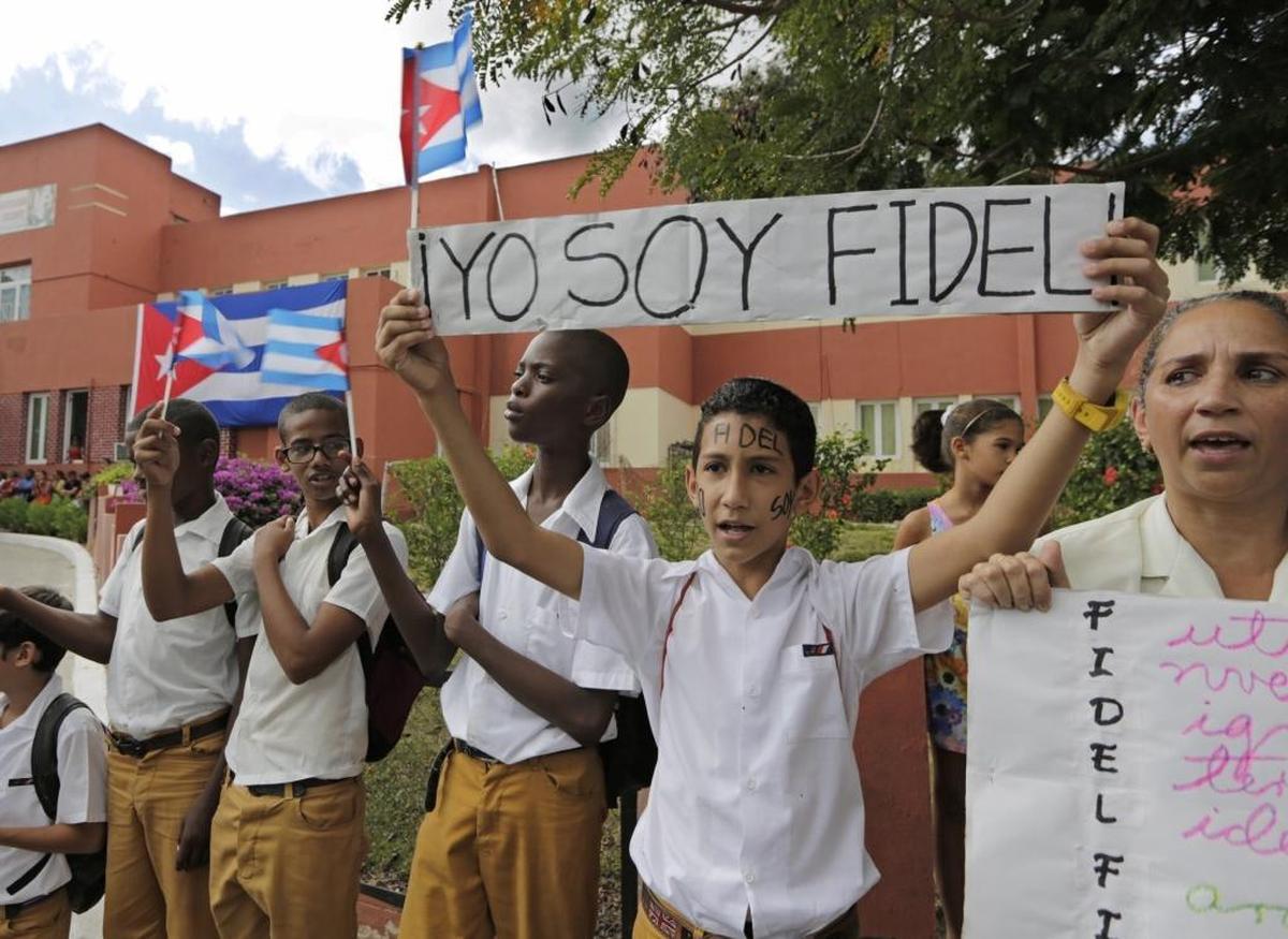 School children wait for the passage of Fidel Castro's ashes outside a clinic on the route to the Moncada Barracks, in Santiago de Cuba, on Dec. 3, 2016.