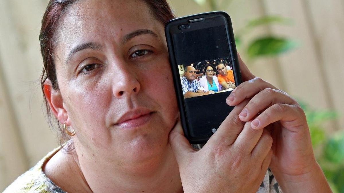 In this file photo Geidy Caraballo shows a picture of her parents Aquilino Caraballo and Georgina Hernández along with her brother Jorge Caraballo.