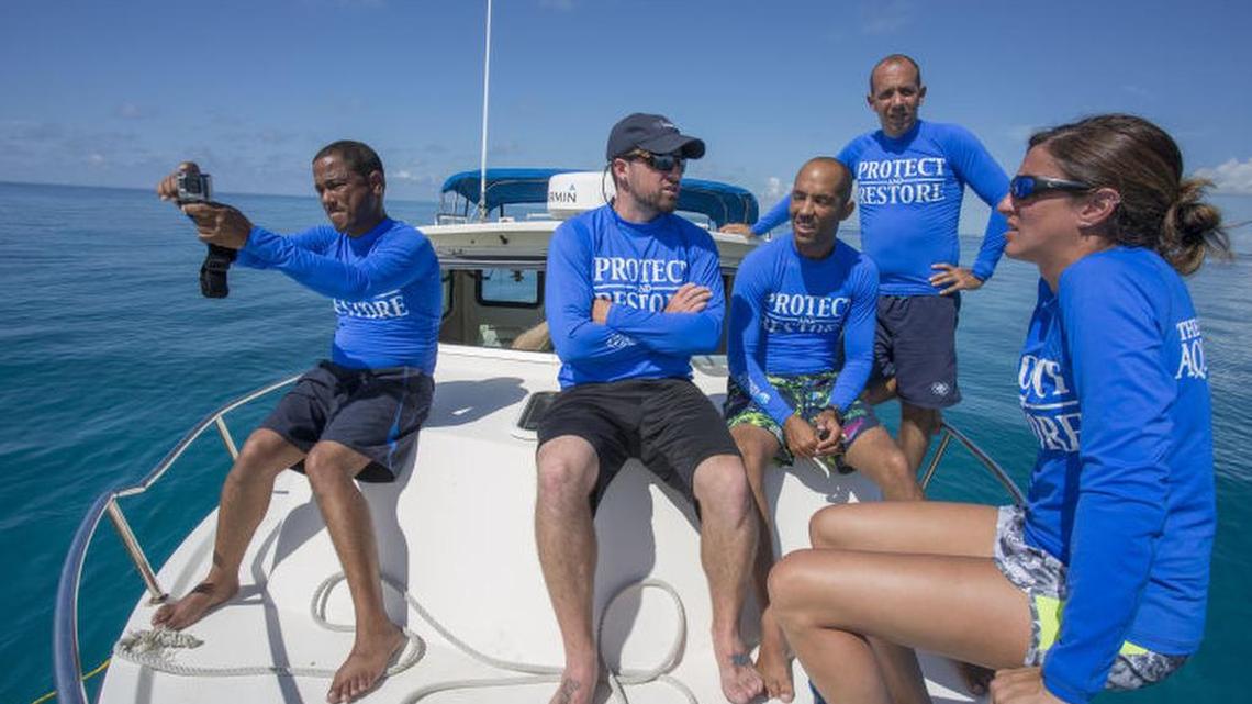 Hanzel Caballero, from the National Aquarium of Cuba, Shawn Garner, Senior Biologist at The Florida Aquarium, Pedro Chevalier, and Alexis Osoria from the National Aquarium of Cuba and Lauren DeLuca, from the Florida Aquarium, hang out together Sunday, August 21, 2016 as they wait for divers to bring up Staghorn coral from an underwater nursery to take to a lab in the Florida Keys.
