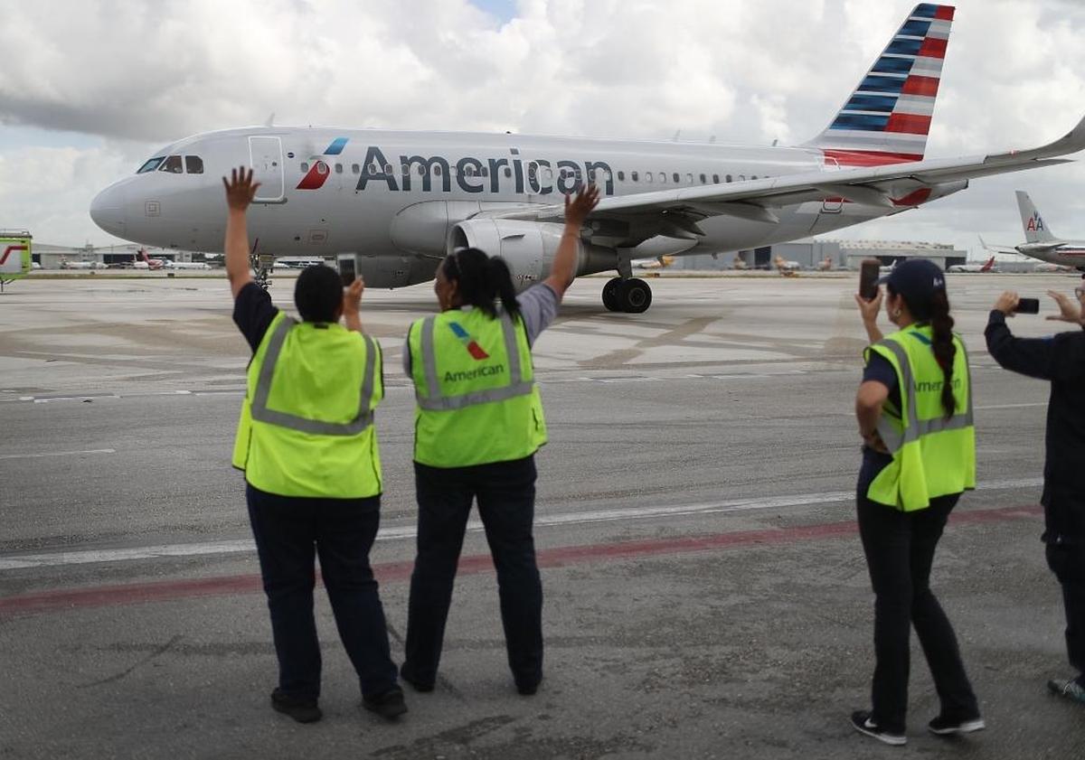 Employees watch as American Airlines Flight 903 prepares for take off, becoming the first regularly scheduled commercial flight from Miami to Cuba in 55 years on September 7, 2016.