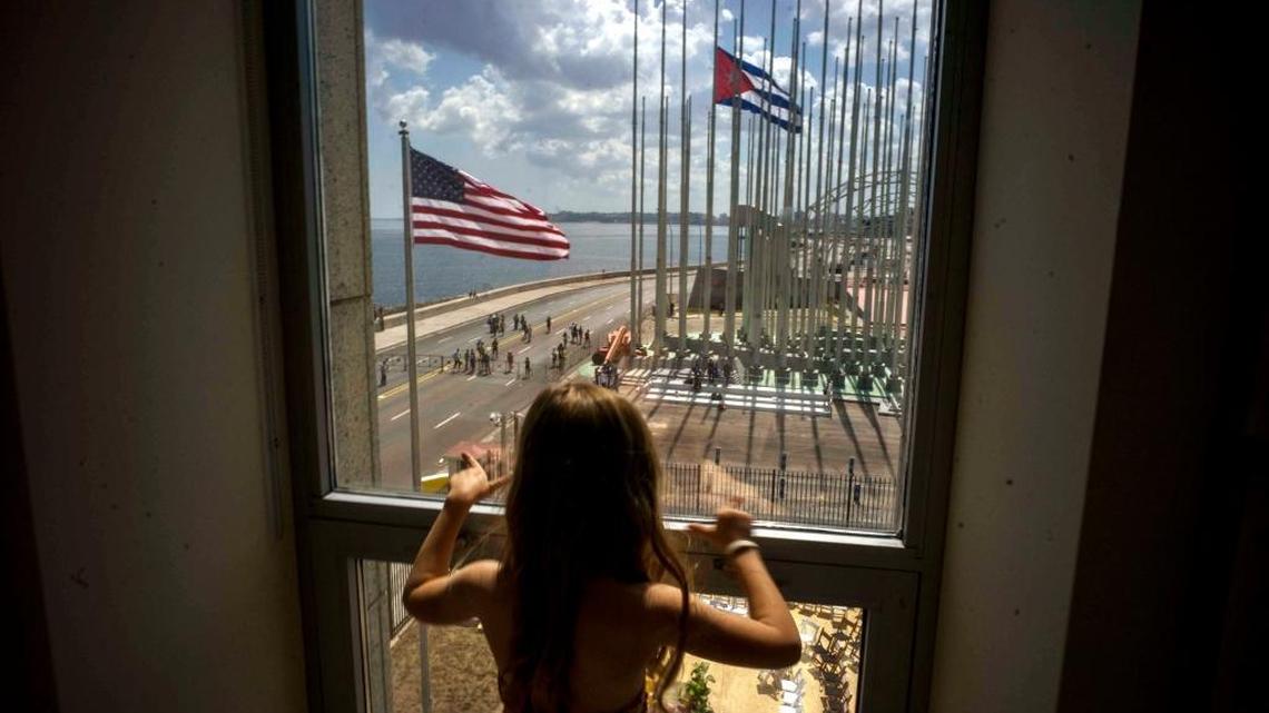 A child looks out a window from inside the newly opened U.S. Embassy at the end of a flag raising ceremony at the U.S. Embassy, in Havana, on Aug. 14, 2015.