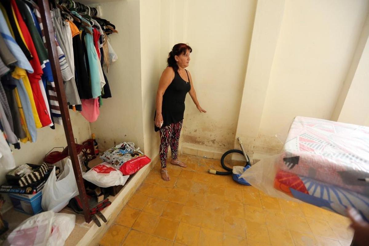 Dalay Menéndez stands in the bedroom of her home along the shoreline in Cojímar, Cuba, and points to the level water reached inside her home during Hurricane Irma. Menendéz evacuated to a neighbor’s home during the storm.