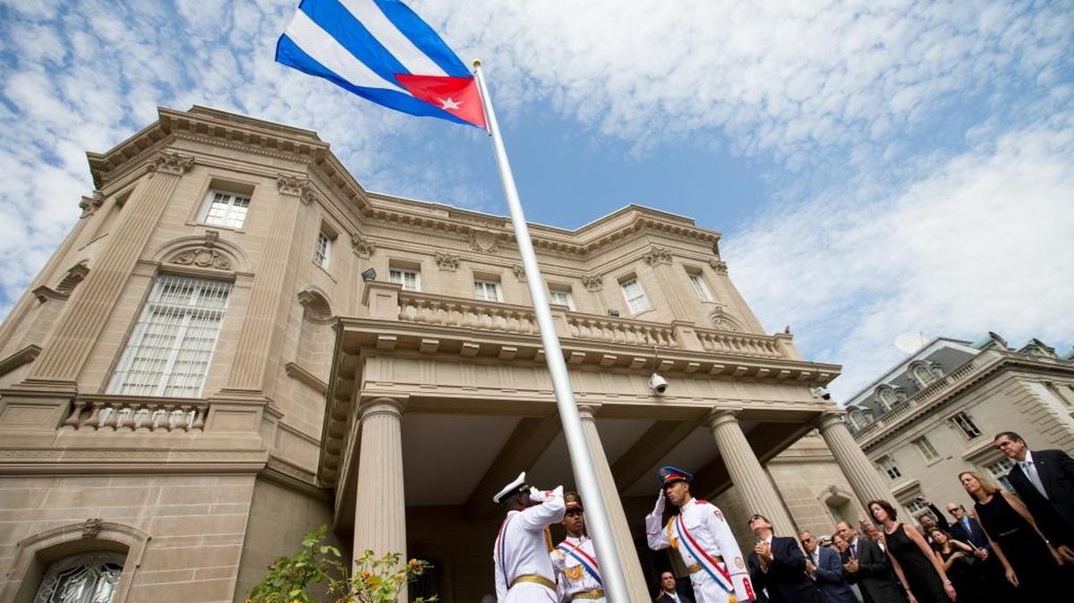 Cuban Foreign Minister Bruno Rodriguez, right of center, applauds with other dignitaries after raising the Cuban flag over their new embassy in Washington, Monday, July 20, 2015.