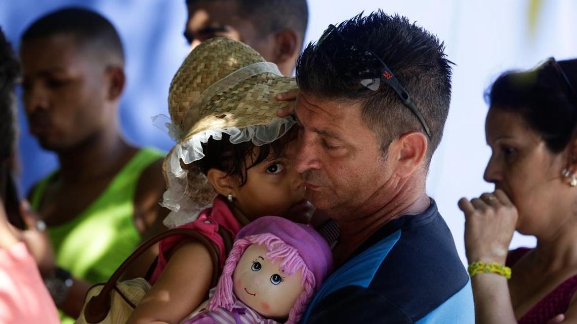 Cuban migrant Denis Gomez, 45, hold up his daughter Dalia Caridad, 4, during a meeting at a shelter in Panama City on Friday. Cubans are coming to grips with a new U.S. immigration policy.